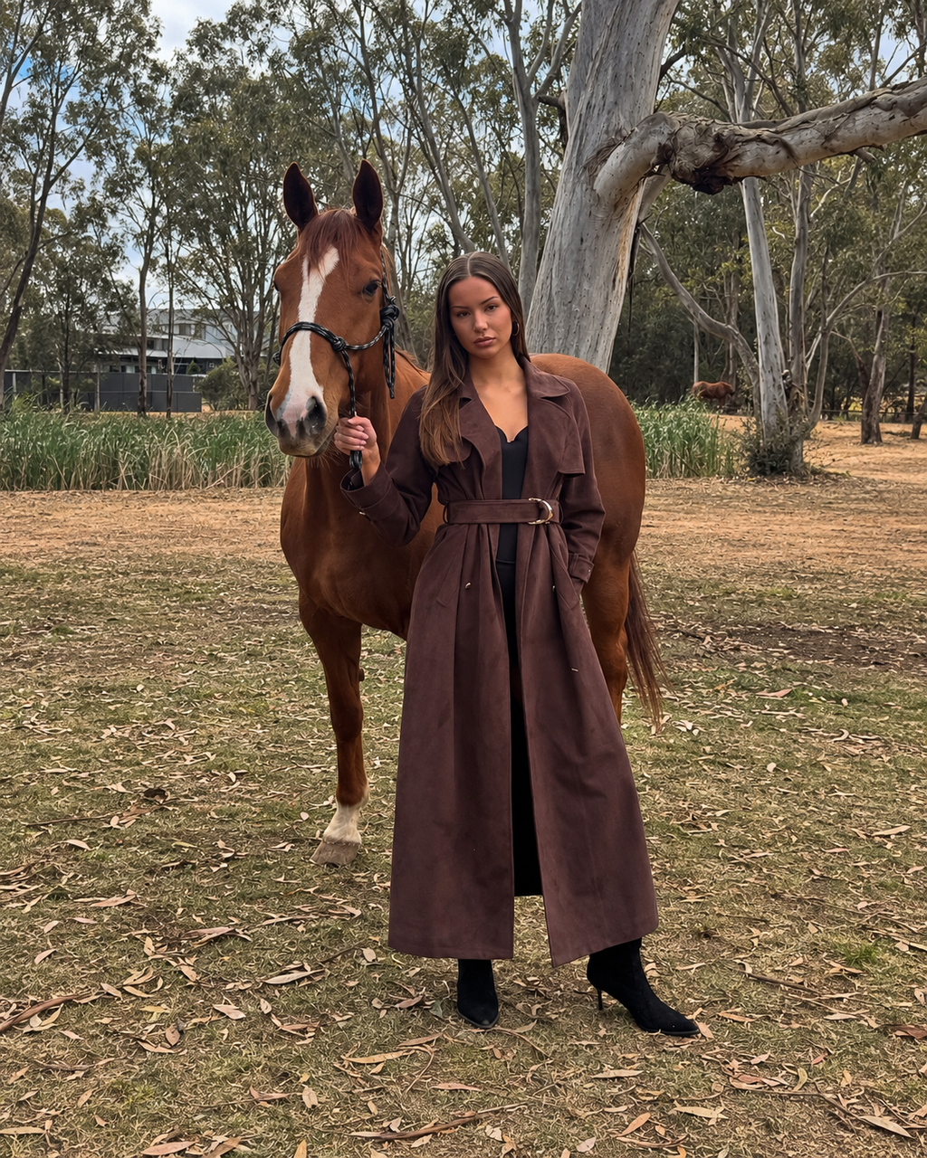 Full-length Flora Trench in espresso suede, modelled beside a horse with full head and ears visible