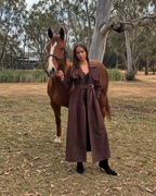Full-length Flora Trench in espresso suede, modelled beside a horse with full head and ears visible